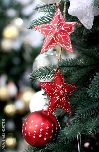 Craft red Christmas tree decorations and Happy New Years decoration hang on green spruce branch