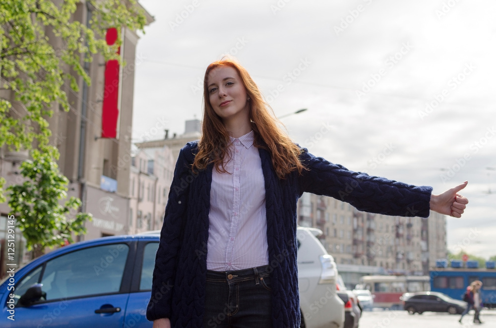 Young red woman is catching taxi