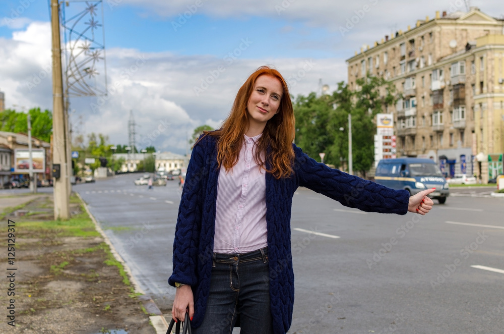 Young red woman is catching taxi Young red woman is catching taxi