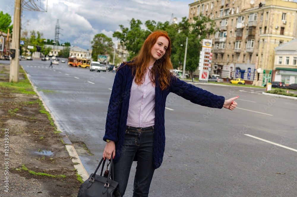 Young red woman is catching taxi