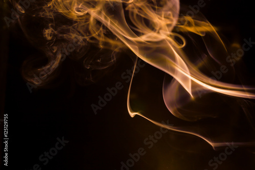 Gold smoke movement on black background.