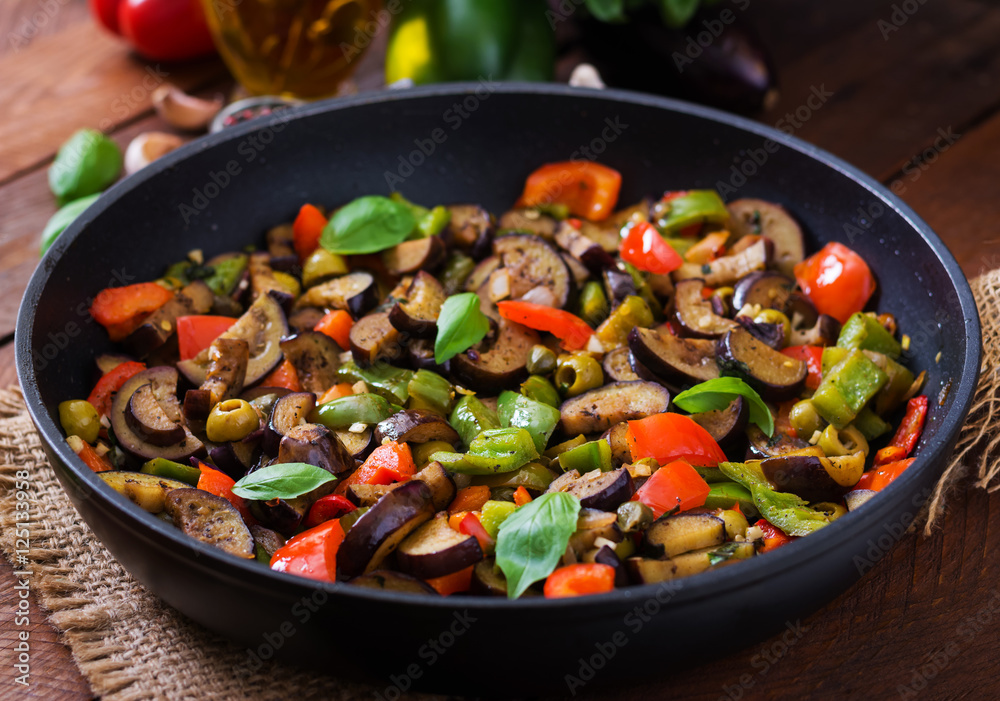 Hot spicy stew eggplant, sweet pepper, olives and capers with basil leaves. Hot spicy stew eggplant, sweet pepper, olives and capers with basil leaves.