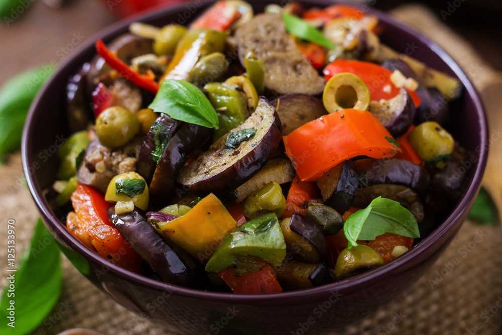 Hot spicy stew eggplant, sweet pepper, olives and capers with basil leaves. Hot spicy stew eggplant, sweet pepper, olives and capers with basil leaves.