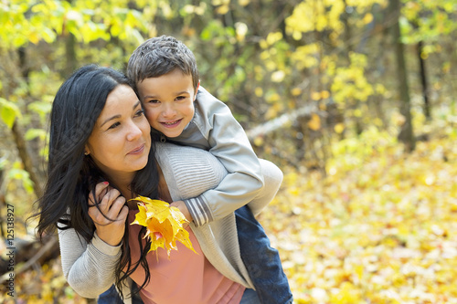 Adorable little boy with his mother in autumn park