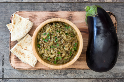 Eggplant baba ganoush and pita bread on wooden background

 photo
