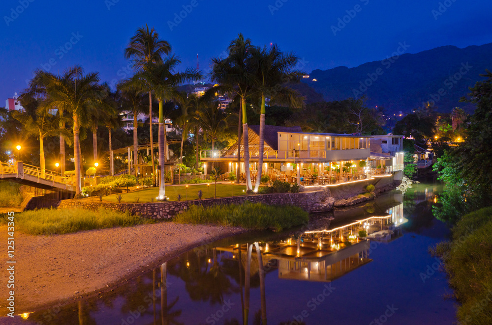 restaurant in night illumination over riverside and mountain view