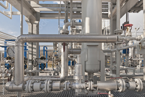 Details of a modern natural gas processing plant with pressure dials on gasworks pipes