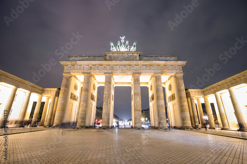 Front view of Brandenburg Gate in Berlin by night - Travel concept with beautiful places landmark in world famous european capital - Composition with wide angle distortion and nightscene color tones