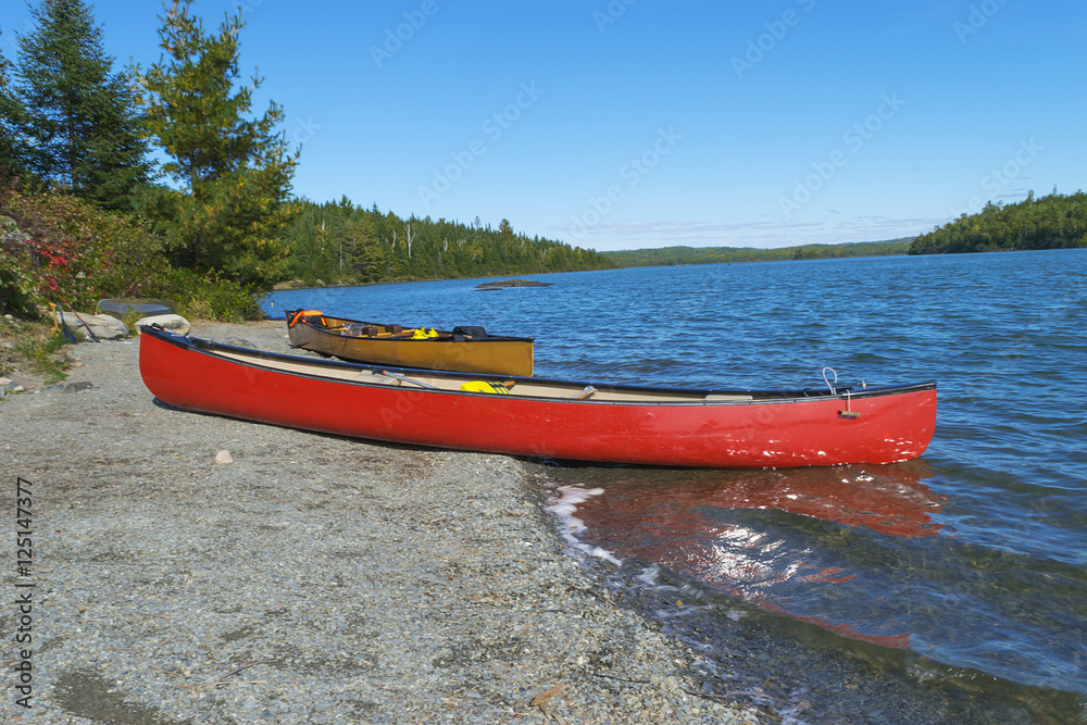 Red canoe on rocky shore of Moose Lake , Boundary Waters Canoe Area,Minnesota, USA Red canoe on rocky shore of Moose Lake , Boundary Waters Canoe Area,Minnesota, USA