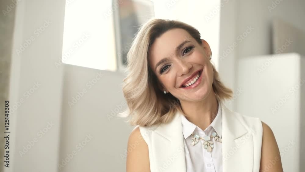 An attractive young woman stands in front of the camera and smiles. Portrait of a successful business woman An attractive young woman stands in front of the camera and smiles. Portrait of a successful business woman