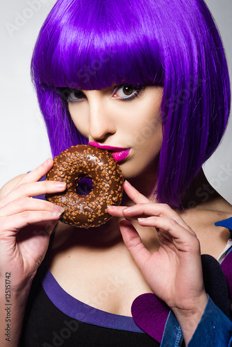 beautiful girl with purple hair. a girl holding a donut