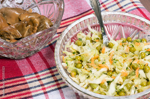 Cabbage salad with peas. Marinated mushrooms in a glass bowl. Rustic style