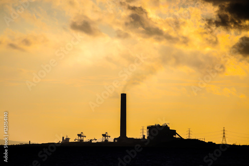 Power plant factory silhouette over sunset at sea © zoneteen