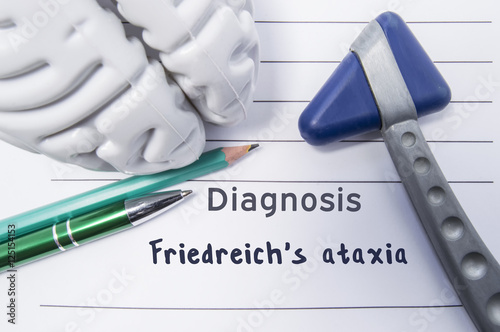 Neurological diagnosis of Friedreich's ataxia. Neurological hammer, shape of brain, pen and pencil the lying on medical report, labeled with diagnosis of Friedreich's ataxia. Concept for neurology
