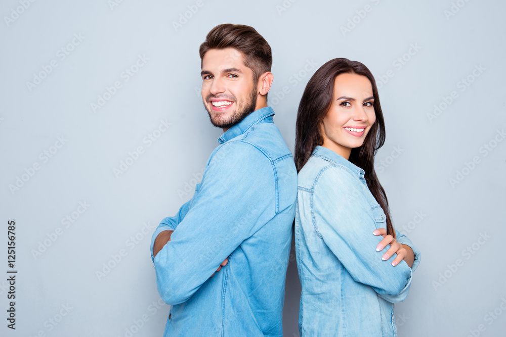Cheerful hsppy man and woman with crossed hands standing back to Cheerful hsppy man and woman with crossed hands standing back to