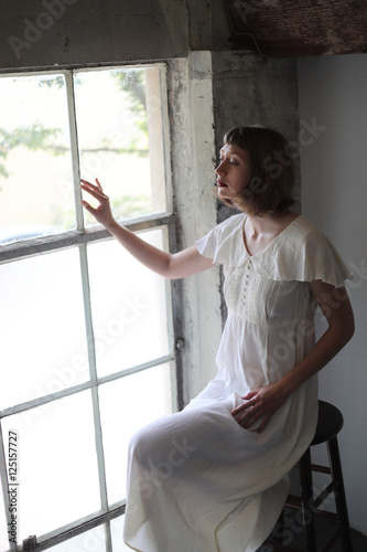 Beautiful Woman in a White Dress in Window Light