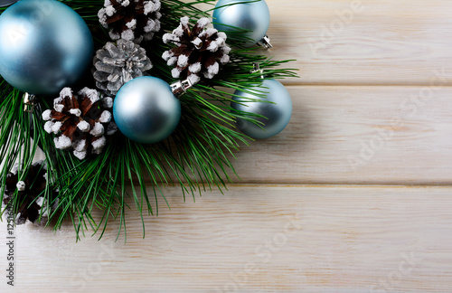 Christmas background with blue ornaments and snowy pinecone