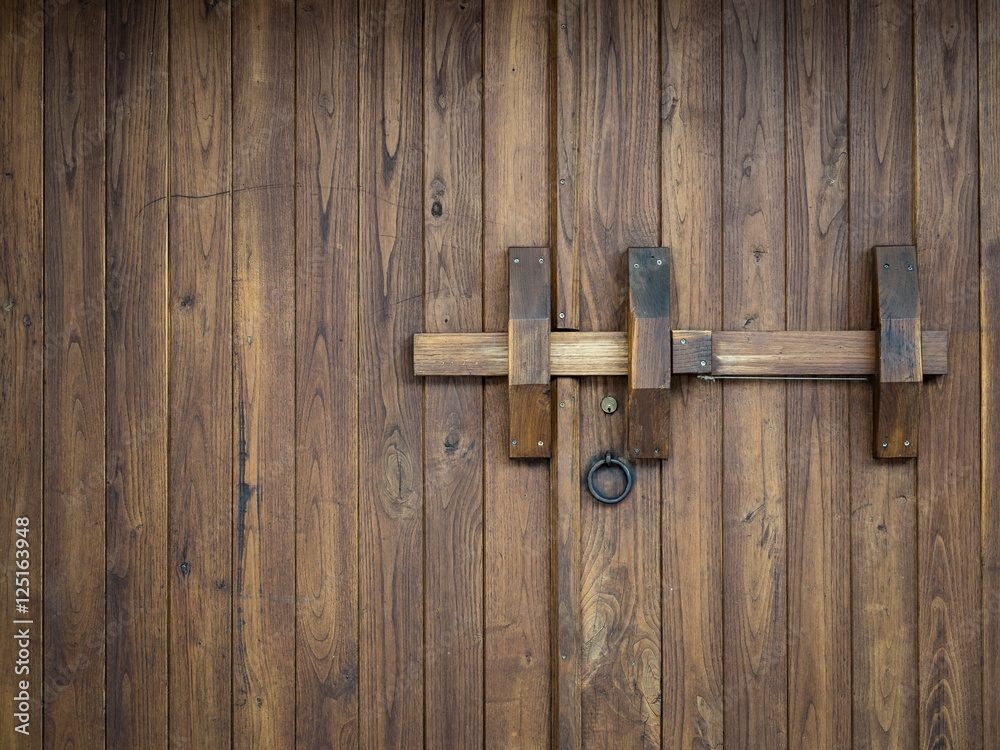 Old wooden gate closed with a big bolt Old wooden gate closed with a big bolt