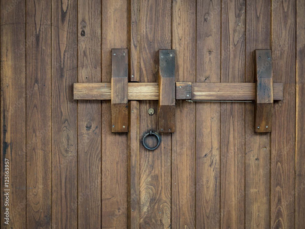 Old wooden gate closed with a big bolt Old wooden gate closed with a big bolt