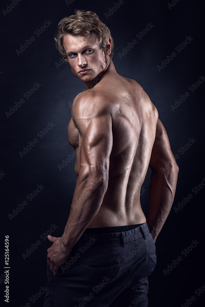 Back view portrait of a muscular man posing on black background  Royalty-Free Stock Image - Storyblocks