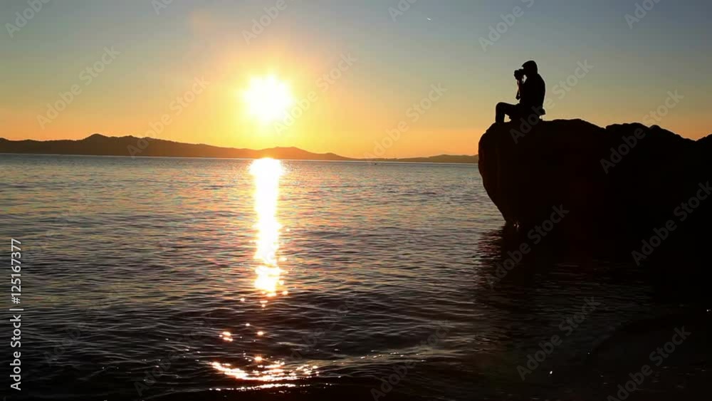 Man recording video of water and landscape in behind at athos mountain