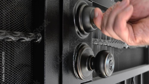 A man unlocks a security door that is set up with a deadbolt and door knob lock system..