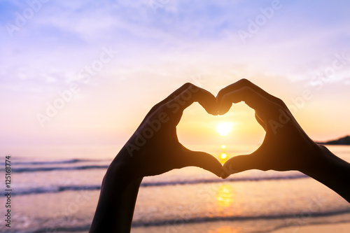 Heart shape, beach and sunset, symbol of romantic travels, love