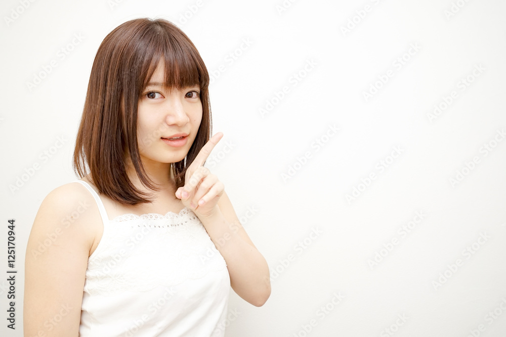 Young woman pointing something with white background