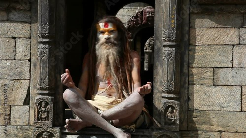 Nepalese sadhu man meditating on the street of Kathmandu photo