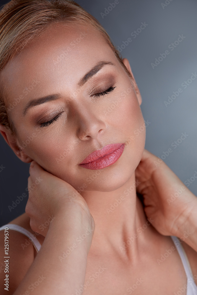 middle aged female touching her neck and smiling