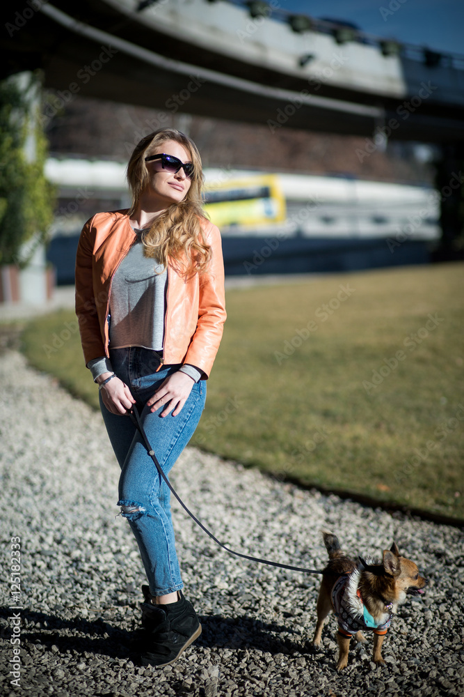 Beautiful young blond woman walks her dog in the Park Beautiful young blond woman walks her dog in the Park
