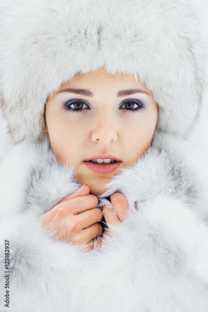 Portrait of a woman in a winter hat on a snow background Portrait of a woman in a winter hat on a snow background