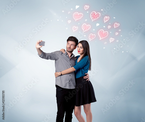 Couple in love taking selfie with red heart