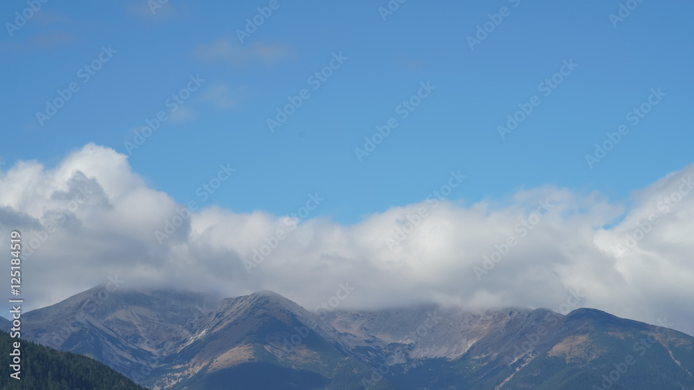 The picturesque mountain on the background of cloud stream. Wide angle