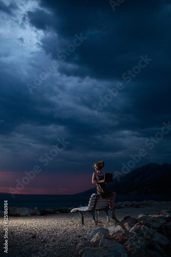 Fototapeta Naklejka Na Ścianę i Meble -  woman with laptop on evening beach
