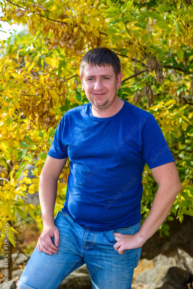 Friendly chubby man standing in autumn foliage Friendly chubby man standing in autumn foliage