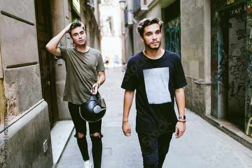 Two young men walking in the street. photo