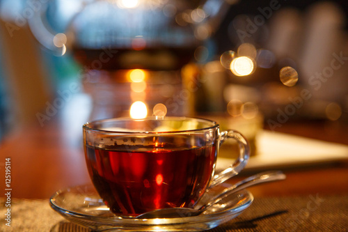 Black tea in glass Cup and glass teapot with a candle stands on