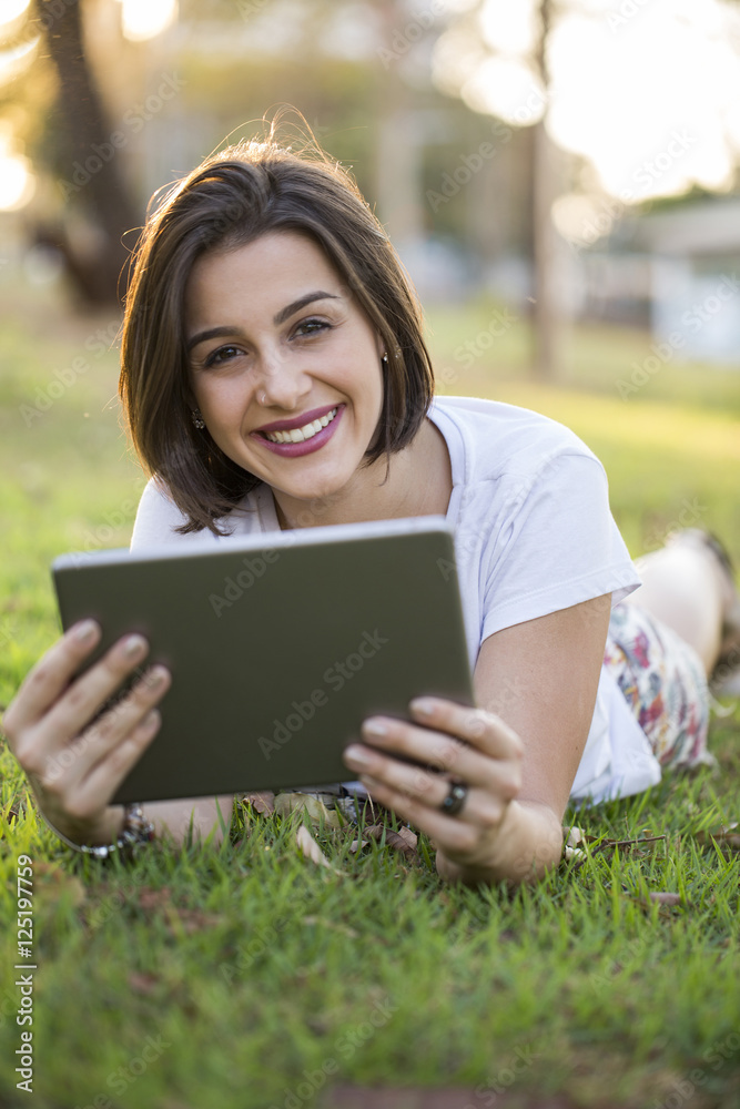 Young woman using tablet in park Young woman using tablet in park