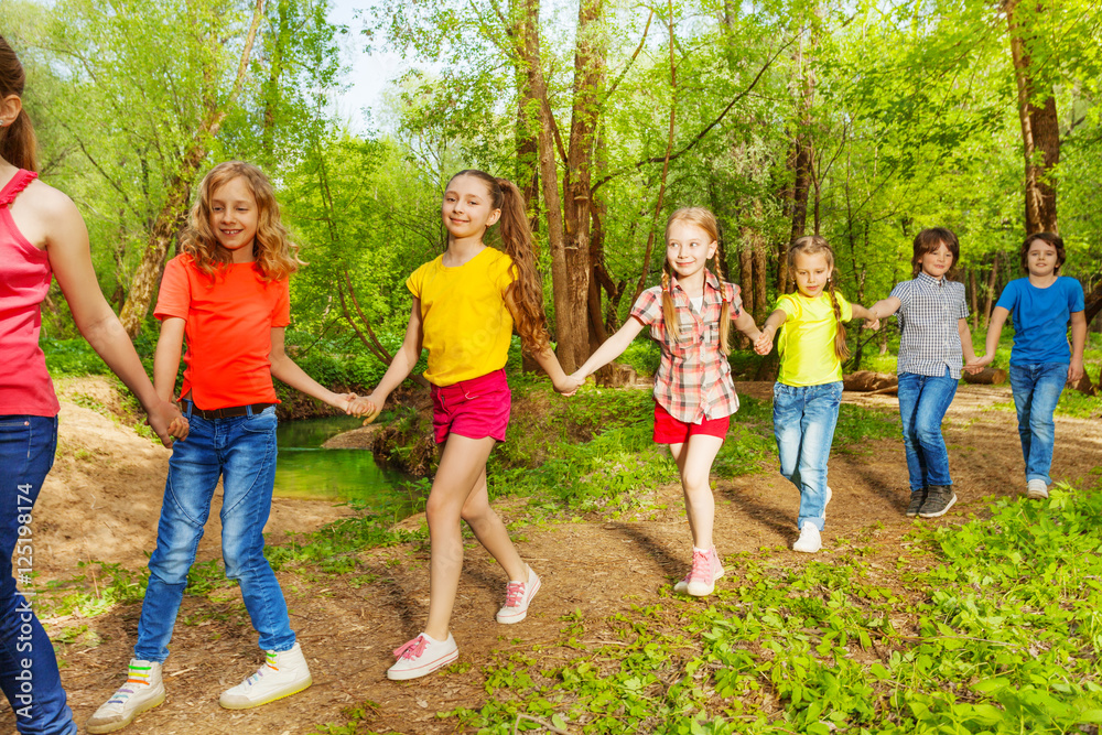 Obraz premium Happy children walking in the forest holding hands