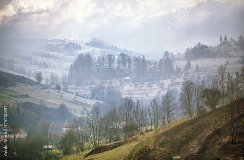 Late autumn misty morning in a village. First Snow