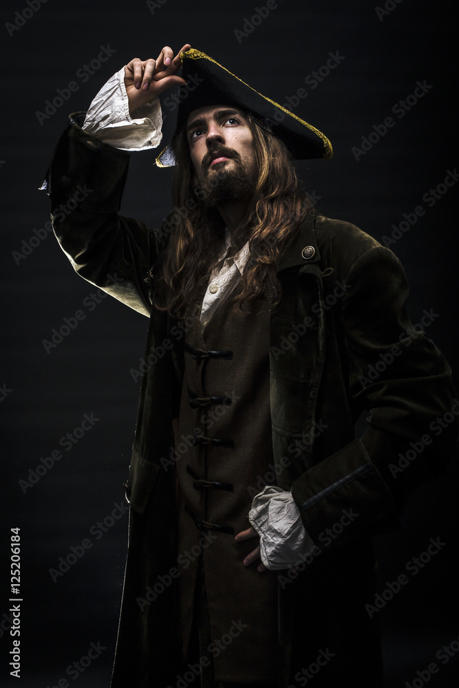 Naklejka premium Portrait of a medieval bearded pirate on black background.