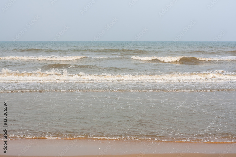 Frothy waves on beach - Incoming high frothy and foamy sea waves on a tropical beach in the evening.