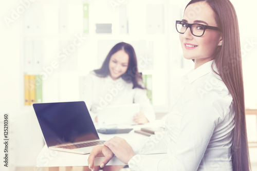 Smiling businesswoman in office with a cheerful colleague © ImageFlow