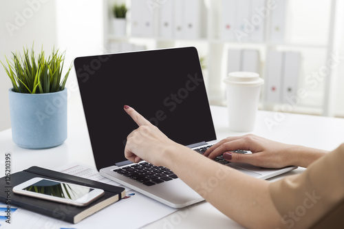 Woman pointing at blank laptop screen