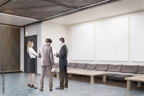 People in office lobby discussing work stuff © ImageFlow