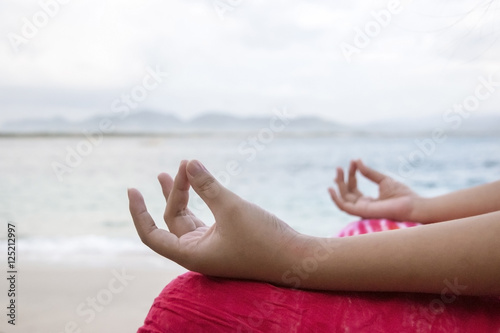 Yoga concept, women hand practicing lotus pose on the beach © Daniel Ferryanto