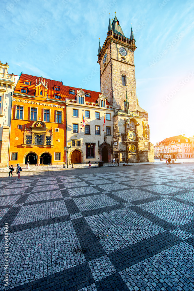 View on the beautiful buildings and town hall with clock tower during the sunrise in the old town of Prague