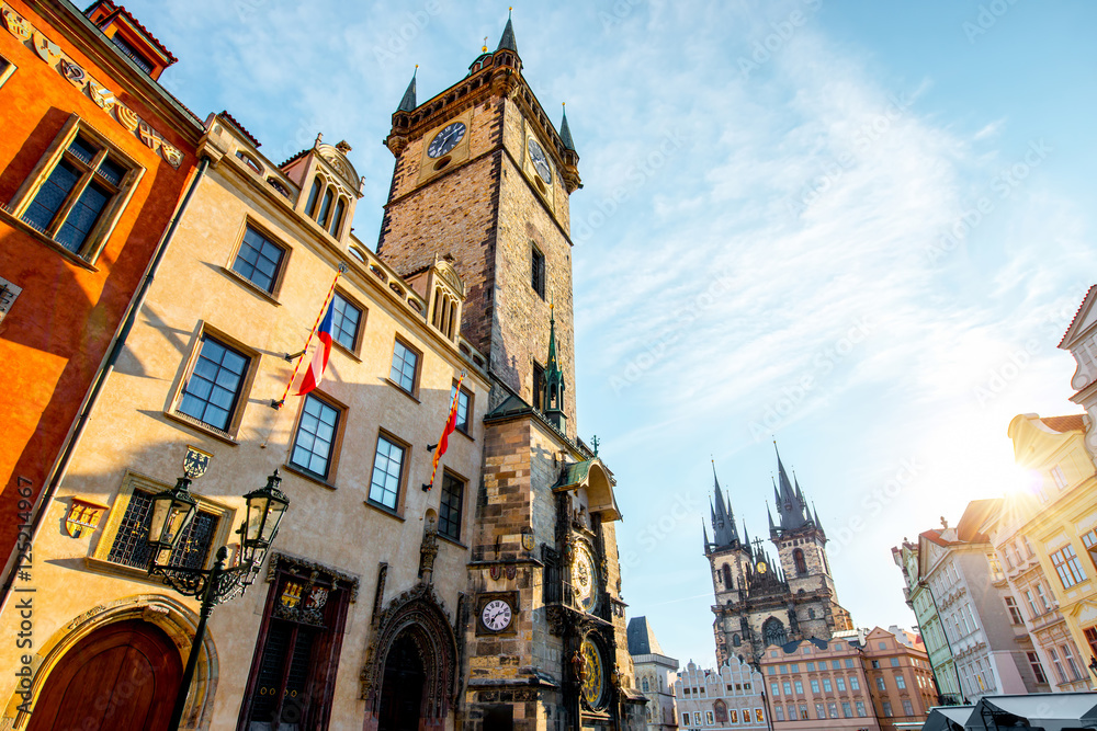 Obraz premium Cityscape view on the clock tower and Tyn cathedral during the sunrise in the old town of Prague