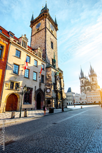 Cityscape view on the clock tower and Tyn cathedral during the sunrise in the old town of Prague